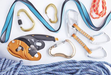 Cesur insanlar için. Üst Manzara. Beyaz masada yatan güvenlik için tırmanma ekipmanları. Ekstrem spor anlayışı.