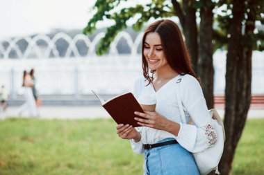 Beyaz ırk kökenli. Genç bir kadın haftasonu parkta iyi vakit geçirir..