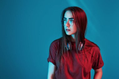 Neon ışıklarıyla aydınlatılmış. Stüdyo içeride çekim yapıyor. Güzel bir genç kızın portresi.