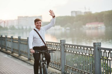 Merhaba, jest. Siyah bisikletli resmi giysili bir işadamı şehirde..