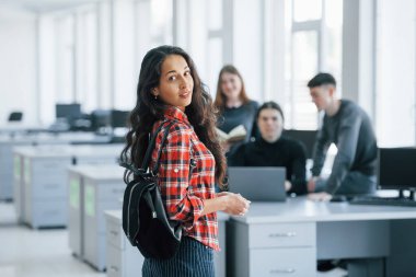 Daha yeni geldim. Modern ofiste çalışan günlük kıyafetli bir grup genç..