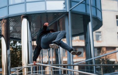 Gündüz vakti şehirde parkçılık yapan genç bir adam. Ekstrem spor anlayışı.