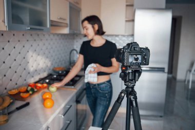 Profesyonel pahalı stüdyo ekipmanları. Günümüz mutfağında hafta sonları evde olan bir kız..