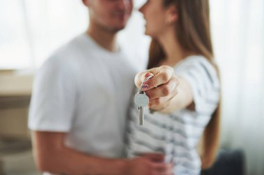 Resim odaklama tekniği. Evin anahtarları. Yeni dairelerinde neşeli genç bir çift. Taşınma kavramı.