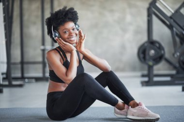 Spor kıyafetlerle. Kıvırcık saçlı Afrikalı Amerikalı kadın spor salonunda spor yapıyor..