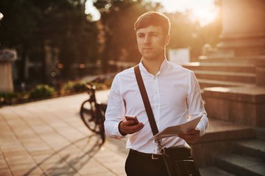 Düşünceli bir bakış. Siyah bisikletli resmi giysili bir işadamı şehirde..