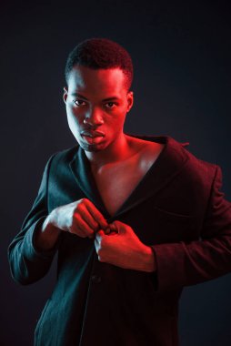Kendinden emin ve ciddi. Fütürist neon ışıkları. Stüdyodaki Afrikalı Amerikalı genç adam..