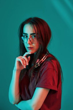 Çekici bir kadın. Stüdyo içeride neon ışıkla çekiliyor. Güzel bir genç kızın portresi.
