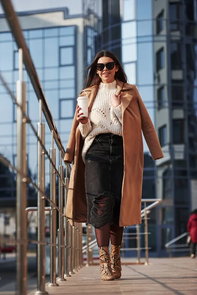 İleriye doğru yürüyorum. Kalın elbiseli genç bir kız hafta sonları şehirde yürür..