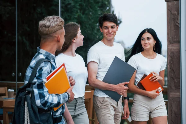 Gündelik giysiler içinde dört genç öğrenci yağmurlu bir günde buluşuyor..