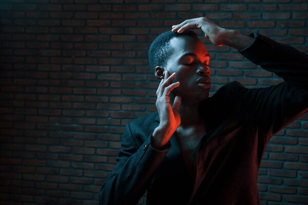 Futuristic neon lighting. Young african american man in the studio.