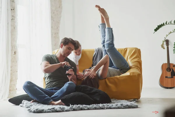 Sentado Suelo Pareja Joven Con Niño Mirando Juntos Las Fotos —  Fotos de Stock