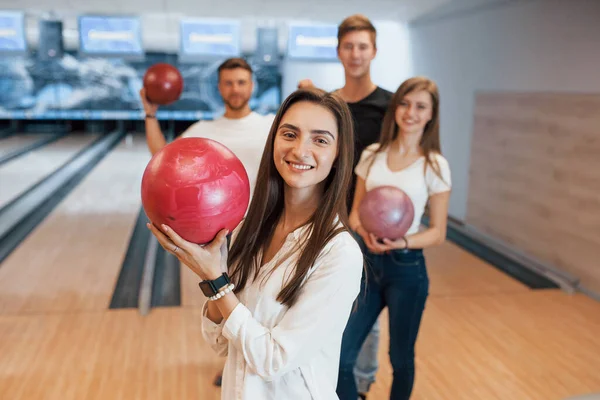 Esmer orada olduğu için mutlu. Genç neşeli arkadaşlar hafta sonları bowling kulübünde eğleniyorlar..