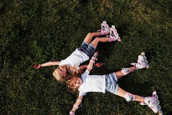 最上階だ 自由を感じる 夏に緑の芝生に寝そべっている2人の女性の子供 — ストック写真