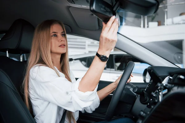 Girando Espejo Hermosa Chica Rubia Sentada Coche Nuevo Con Interior — Foto de Stock