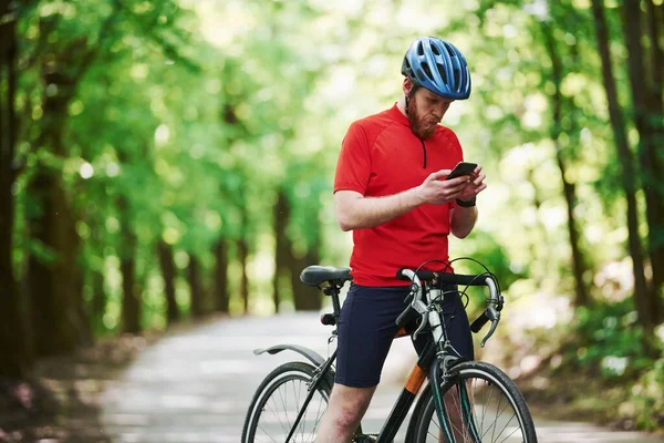 Usando Smartphone Ciclista Uma Bicicleta Está Estrada Asfalto Floresta Dia — Fotografia de Stock