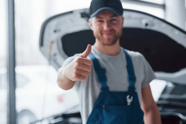 Dobrá Práce Zaměstnanec Modré Uniformě Stojí Automobilovém Salonu — Stock fotografie