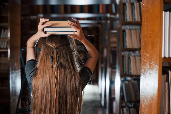 Chica Alegre Divertirse Mientras Pone Libros Cabeza Estudiante Está Biblioteca — Foto de Stock