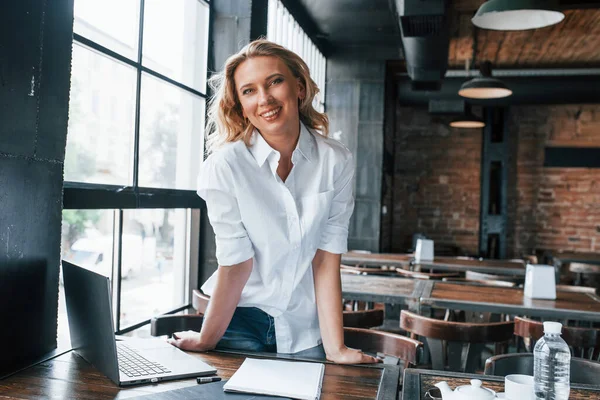 Uśmiechasz Się Kamery Bizneswoman Kręconymi Blond Włosami Wewnątrz Kawiarni Ciągu — Zdjęcie stockowe