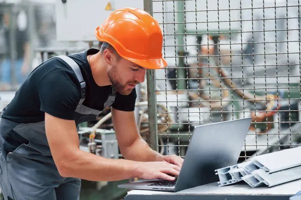 Modern Laptop Fabrikada Sanayi Işçisi Turuncu Şapkalı Genç Teknisyen — Stok fotoğraf