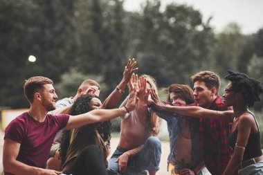 Başarıyı kutluyoruz. Bir grup insan sahilde piknik yapıyor. Arkadaşlar hafta sonu eğlenir..