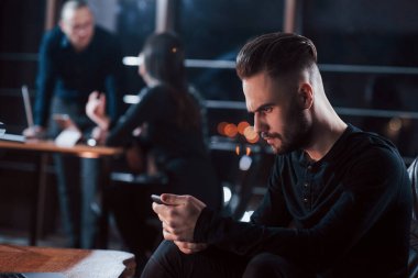 Sonuçlar için endişeleniyorum. Genç iş adamlarından oluşan bir ekip gece ofiste projeleri üzerinde çalışıyor..