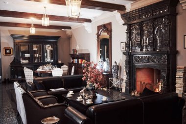 Çiçekler, fincanlar, masalar ve divanlar. Lüks bir restoranın içinde, güzel şömineli klasik aristokrat tarzında..