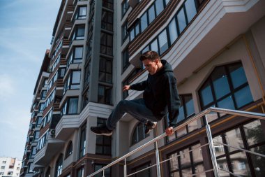 Gündüz vakti şehirde parkçılık yapan genç bir adam. Ekstrem spor anlayışı.