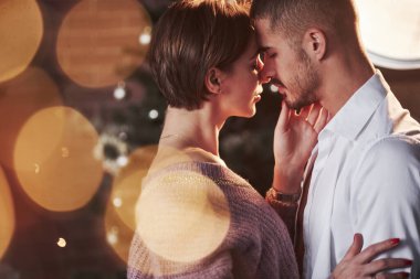 Bu akşam birlikte olmak bir zevk. Güzel bir çift, kapalı alanda yeni yılı kutluyor. Üzerlerinde klasik güzel giysiler var..