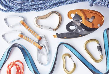 Acemi ve profesyonellere göre ayarlanıyor. Üst Manzara. Beyaz masada yatan güvenlik için tırmanma ekipmanları. Ekstrem spor anlayışı.