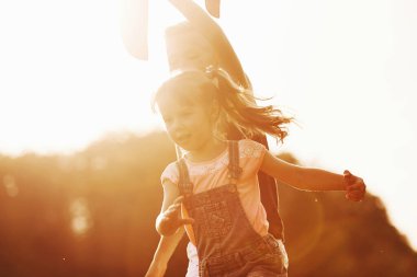 Güzel güneş ışığıyla aydınlatılmış. Kız ve erkek ellerinde eğleniyorlar..