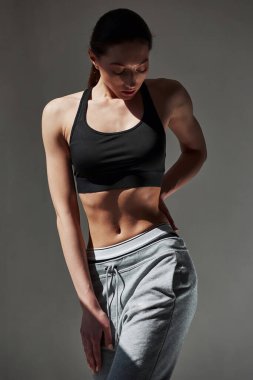 Rahat bir giysi. Beyaz tenli güzel kadın gündüz vakti stüdyoda duvara yaslanıyor..