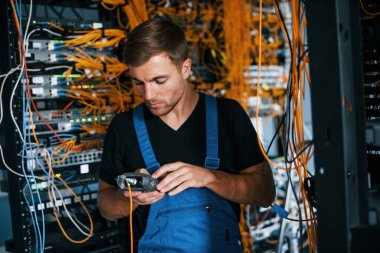 Üniformalı genç adamın sunucu odasında internet teçhizatı ve dinleme cihazlarıyla ilgili bir işi var..