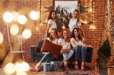 Neşeli kadınlar yılbaşı tatillerini kapalı bir yerde, parlak noel süslemeli odada kutlayarak eğlenirler..