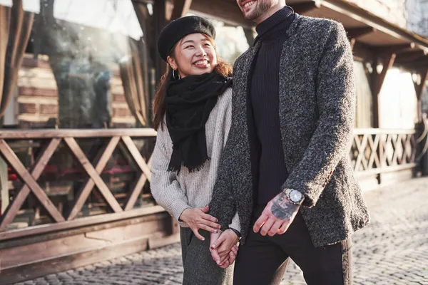 Çok kültürlü bir çift şehirde yürüyüş yapar ve birbirlerini kucaklarlar..