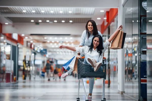 Twee Jonge Vrouwen Hebben Plezier Door Rennen Rijden Winkelmand Supermarkt — Stockfoto