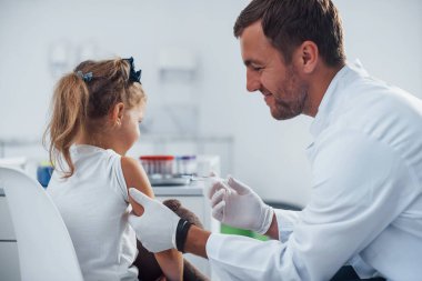 Kan örnekleri. Küçük kız doktorla klinikte..