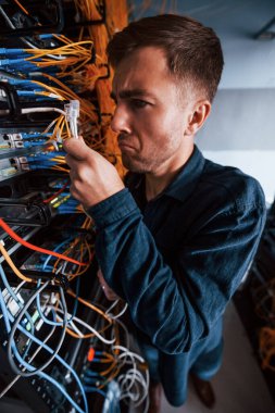Sunucu odasında internet kablosu olan komik adamın yakın görüntüsü.