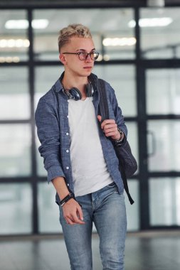 Gündelik giysiler içinde genç bir öğrenci sırt çantasıyla içeri giriyor..