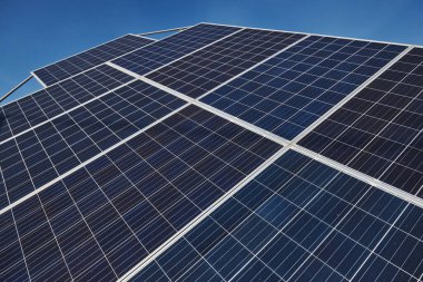 Güneşli bir günde güneş pillerinin cilalanmış yüzeyinin yakın görüntüsü.