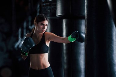 Spor kıyafetli genç bir kadın spor salonunda egzersiz yapıyor. Boks kavramı.