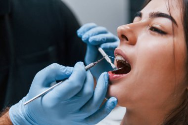 Dişçi kliniğine gelen genç yetişkin kadının yakın görüntüsü. Stomatoloji kavramı.