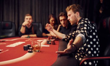 Kumarhanede poker oynayan bir grup zarif gencin yan görüntüsü..