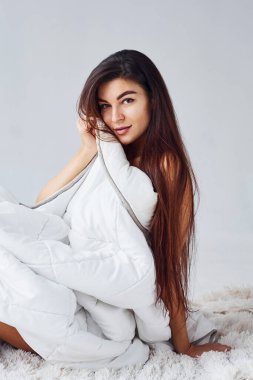 Stüdyoda beyaz arka planda iç çamaşırlı bir kadın.