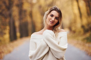 Kalın giysiler içinde. Gündüz vakti sonbahar ormanındaki genç esmerin portresi..