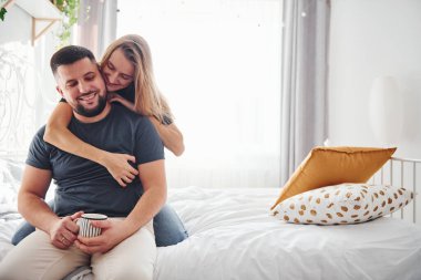 Bir bardak içki. Genç evli çiftler gündüzleri yatak odasında vakit geçirirler..