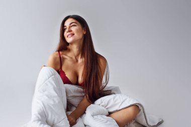 Stüdyoda beyaz arka planda iç çamaşırlı bir kadın.