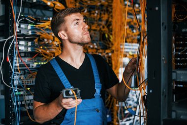 Üniformalı genç adamın sunucu odasında internet teçhizatı ve dinleme cihazlarıyla ilgili bir işi var..