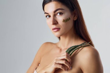 Çıplak kadın stüdyoda beyaz arka plana karşı aloe vera ile birlikte..