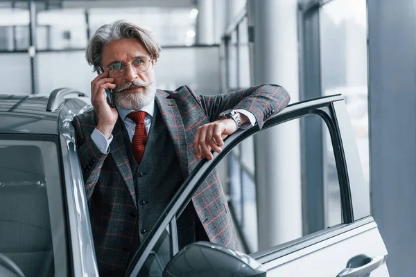 Starszy Biznesmen Garniturze Krawacie Siwymi Włosami Brodą Stojący Wewnątrz Telefonem — Zdjęcie stockowe